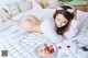 A woman laying on a bed with a plate of cherries.