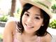 A woman in a straw hat smiles at the camera.