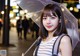 A woman holding an umbrella in the rain at night.