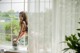 A woman sitting on a window sill holding a disco ball.