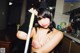 A woman in a cat costume holding a broom.